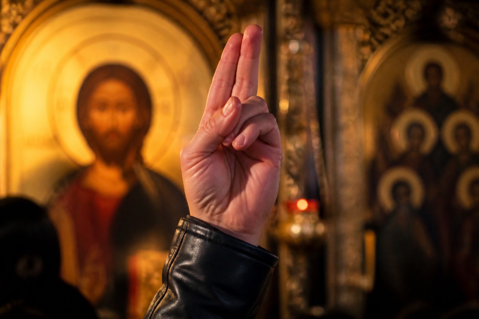 O mână de credincios ortodox făcând semnul crucii cu trei degete unite.